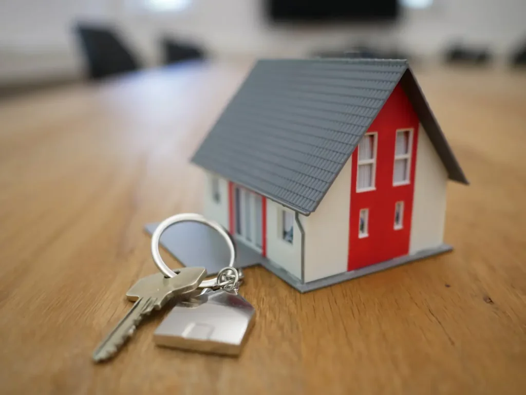 House model on cash stack representing real estate deals in Zambezi Estate.